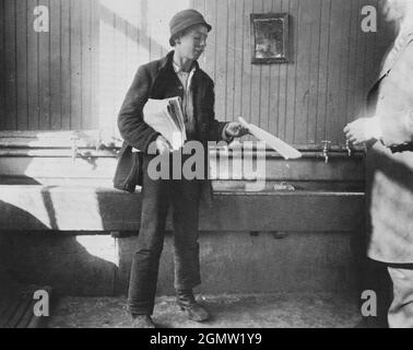 Jacob Riis photography - Newsboy in the Duane Street Lodging House - Newsbo che plying il suo commercio di vendere i giornali - Sink trough in background. Foto Stock