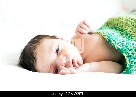 Un bambino in costume caterpillar sdraiato su sfondo bianco Foto Stock