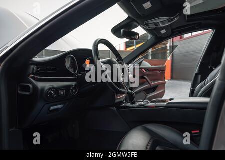Ucraina, Odessa - 8 settembre 2021: Interni moderni dell'automobile di lusso - volante e cruscotto. Pozzetto nero. Interni di veicoli di lusso. Foto Stock