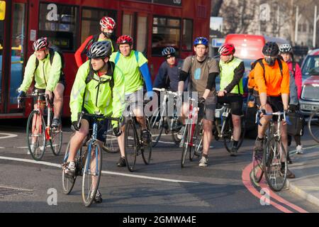 Londra, Inghilterra - 30 marzo 2012 Un grande gruppo di ciclisti che aspetta pazientemente al semaforo di trasformarsi in Victoria Embankment da Westminster Bridg Foto Stock