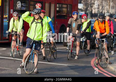 Londra, Inghilterra - 30 marzo 2012 Un grande gruppo di ciclisti che aspetta pazientemente al semaforo di trasformarsi in Victoria Embankment da Westminster Bridg Foto Stock