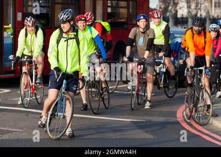 Londra, Inghilterra - 30 marzo 2012 Un grande gruppo di ciclisti che aspetta pazientemente al semaforo di trasformarsi in Victoria Embankment da Westminster Bridg Foto Stock