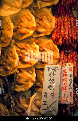 Hong Kong, 1983; le finestre del macellaio cinese non sono per i vegani o lo stridio. Possono far sì che anche me - un carnivoro confermato e onnivoro - si senta un bi Foto Stock