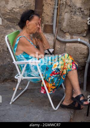 Palermo, Sicilia, Italia - 23 settembre 2019; una donna in shot. Questa donna anziana caratterizzante stava avendo una siesta di mezzogiorno nella piazza di fronte a Palermo Foto Stock