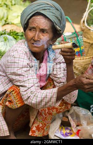 Bagan, Myanmar - 28 gennaio 2013; una donna anziana in colpo. Vecchia donna tribale che fuma un sigaro fatto in casa e arrotolato a mano in Nyaung - U Market Foto Stock