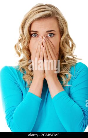 Scioccata donna polacca in abiti blu coprendo la bocca isolato su sfondo bianco Foto Stock