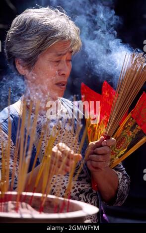 Hong Kong, Cina - 7 giugno 2006; una donna anziana in colpo. Situato a nord di Kowloon, il Wong Tai Sin è il tempio taoista più popolare di Hong Kong. Foto Stock