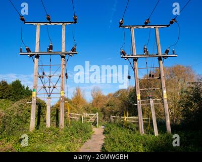 Oxfordshire, Inghilterra - 31 Ottobre 2018 Un paio di tralicci di elettricità a Kennington, da entrambi i lati di un sentiero pedonale e ciclabile attraverso la campagna t Foto Stock