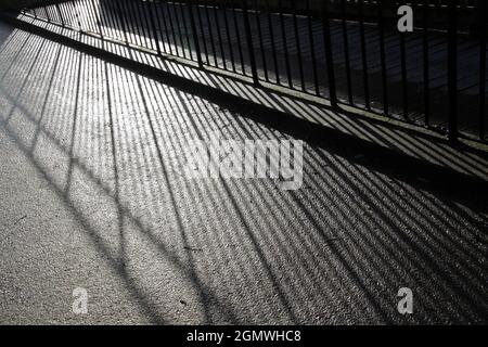 Oxfordshire, Inghilterra - 22 Aprile 2016 la luce del sole ad angolo basso che brilla attraverso queste ringhiere metalliche in Abbey Fields, Oxfordshire, crea questa piacevole abstra Foto Stock