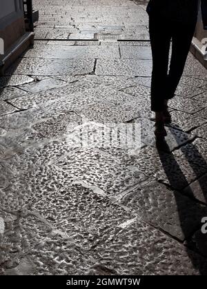 Palermo, Sicilia, Italia - 23 settembre 2019 un uomo e la sua ombra sulle antiche ciottoli nel cuore del centro storico del Capo Siciliano Foto Stock