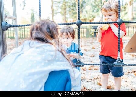 madre che parla con il suo figlio di uno e tre anni circa le regole di comportamento nel parco. concetto di istruzione Foto Stock