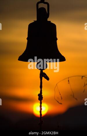 Dambulla, Sri Lanka - 9 febbraio 2014 c'è qualcosa di estremamente suggestivo su una campana che si fa a pedaggio al tramonto, alla morte del giorno... Foto Stock