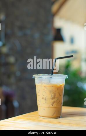 Caffè ghiacciato in vetro sul tavolo di legno sfondo sfocato. Foto Stock