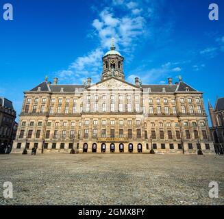 Amsterdam, Paesi Bassi - 27 maggio 2016; due persone in vista. Il Palazzo reale di Amsterdam fu costruito come municipio durante l'Età dell'Oro olandese nel 17t Foto Stock