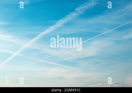Bianco croccante sentieri di aeroplani, tracce di aerei su cielo blu come sfondo Foto Stock