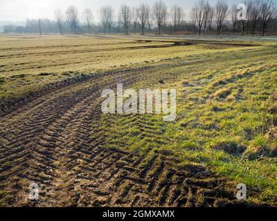 Radley Village, Oxfordshire, Regno Unito - 9 marzo 2021; non ci sono persone in vista. I percorsi del trattore si snodano su un campo in Lower Radley, come una cicatrice gigante in tutto il Foto Stock