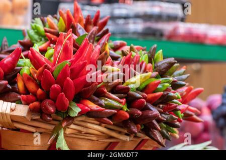 Mazzi di peperoncini rossi e verdi in un cestino in un mercato di Street food, da vicino Foto Stock