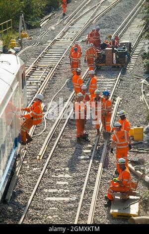 I lavoratori di rete ferroviaria/rete che eseguono il lavoro di base – sostituzione dei binari con macchinari pesanti e treni di ingegneria. Modernizzare le moderne traversine in legno con moderne traversine in cemento e nuove rotaie a Twickenham, nella zona ovest di Londra. REGNO UNITO (127) Foto Stock