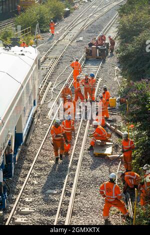 I lavoratori di rete ferroviaria/rete che eseguono il lavoro di base – sostituzione dei binari con macchinari pesanti e treni di ingegneria. Modernizzare le moderne traversine in legno con moderne traversine in cemento e nuove rotaie a Twickenham, nella zona ovest di Londra. REGNO UNITO (127) Foto Stock