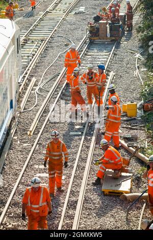 I lavoratori di rete ferroviaria/rete che eseguono il lavoro di base – sostituzione dei binari con macchinari pesanti e treni di ingegneria. Modernizzare le moderne traversine in legno con moderne traversine in cemento e nuove rotaie a Twickenham, nella zona ovest di Londra. REGNO UNITO (127) Foto Stock