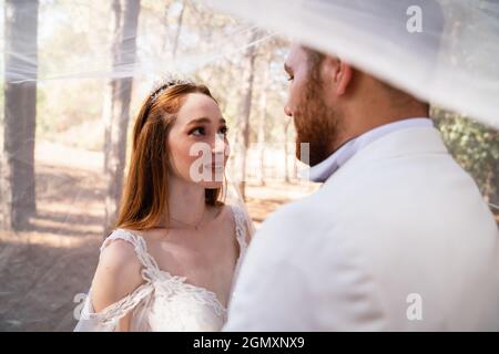 Sposare e sposare insieme, e guardare eachother con gli occhi aperti affascinati. Concetto di matrimonio. Foto di alta qualità Foto Stock