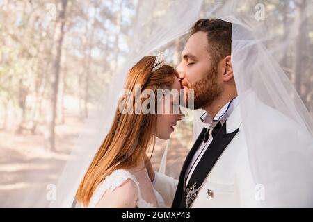 Sposare e sposare insieme, e guardare eachother con gli occhi aperti affascinati. Concetto di matrimonio. Foto di alta qualità Foto Stock