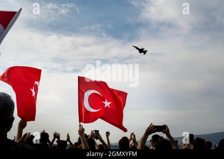 Izmir, Turchia - 9 settembre 2021: Aerei che volano in cielo il giorno della libertà di Izmir per una dimostrazione. Persone che sventolano una bandiera turca nella cornice Foto Stock