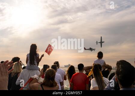 Izmir, Turchia - 9 settembre 2021: Aerei che volano in cielo il giorno della libertà di Izmir per una dimostrazione. Persone che sventolano una bandiera turca nella cornice Foto Stock