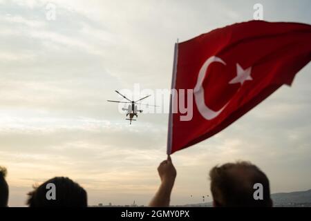 Izmir, Turchia - 9 settembre 2021: Elicottero di polizia turco Atak e una bandiera turca nella stessa cornice delle celebrazioni della giornata di liberazione di Izmir Foto Stock