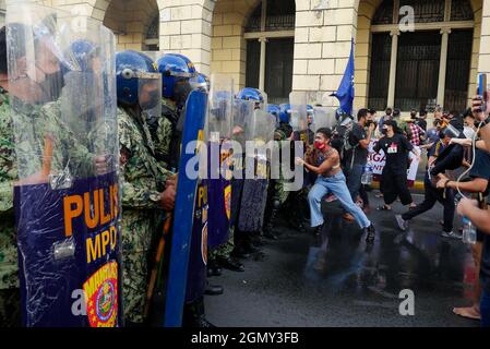 Manila, Regione capitale Nazionale, Filippine. 21 settembre 2021. Una protesta tenuta il giorno in cui la legge marziale è stata dichiarata il 21 settembre 1972. Tuttavia, la polizia di Manila blocca un gruppo di manifestanti diretti al monumento Andres Bonifacio. Si radunarono per la prima volta a Carriedo, a Manila. Poi la polizia blocca e disperdere il gruppo con scudo, bastoni e un canone d'acqua.Un manifestante cerca di spingere un blocco della polizia mentre un cannone d'acqua ha sparato contro di loro. (Credit Image: © George Buid/ZUMA Press Wire) Foto Stock