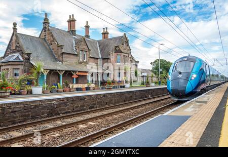 Treno elettrificato Azuma che passa attraverso la stazione ferroviaria di Chathill, classificata di grado 2, sulla linea principale della costa orientale. Foto Stock