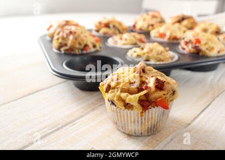 Gustosi muffin per pizza al forno come stuzzichini per una festa da pasta di lievito, pomodori, verdure, salsiccia e formaggio su un tavolo di legno, spazio copia, selecte Foto Stock