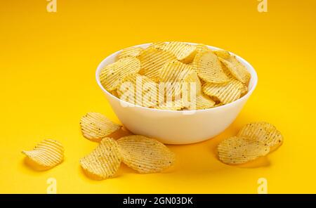 Patatine fritte in ciotola su sfondo giallo Foto Stock