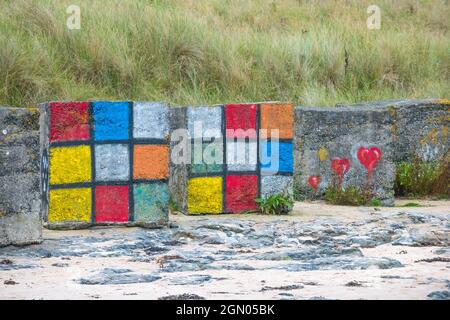 Grandi blocchi di cemento usati come difesa anticarro della seconda guerra mondiale dipinte come morsi o cubi rubik. Foto Stock