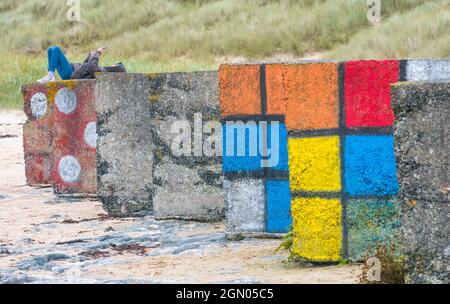 Grandi blocchi di cemento usati come difesa anticarro della seconda guerra mondiale dipinte come morsi o cubi rubik. Foto Stock