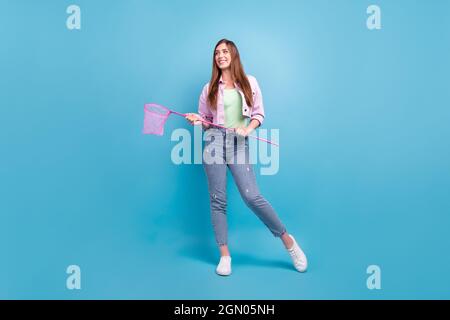 Intera lunghezza corpo dimensione foto sorridente ragazza indossare casual vestito mantenendo netto guardando copyspace isolato pastello blu sfondo colore Foto Stock