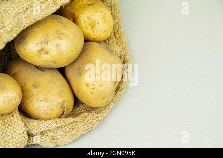 Raccolta di patate grandi fresche in un sacchetto. Prodotti alimentari Foto Stock