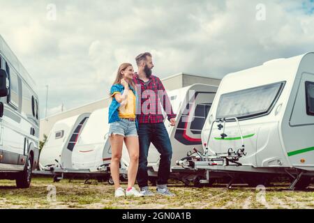 Donna e uomo che scelgono il camper da affittare o acquistare Foto Stock