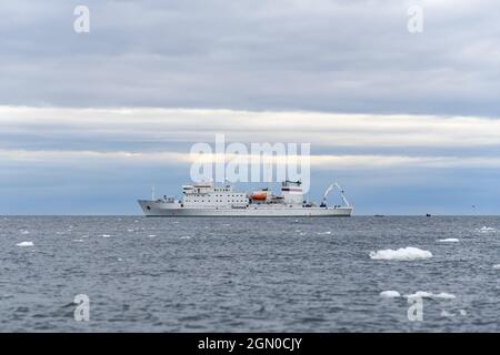 Spedizione nave in mare artico con ghiaccio. Vaso di ricerca bianco. Foto Stock