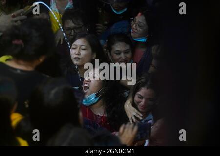 Kathmandu, Nepal. 21 settembre 2021. Le donne nepalesi lottano per bere l'alcool fatto in casa dalla bocca della divinità Swet Bhairav come benedizioni durante il festival Indra Jatra a Kathmandu, Nepal il martedì 21 settembre 2021. (Credit Image: © Skanda Gautam/ZUMA Press Wire) Foto Stock
