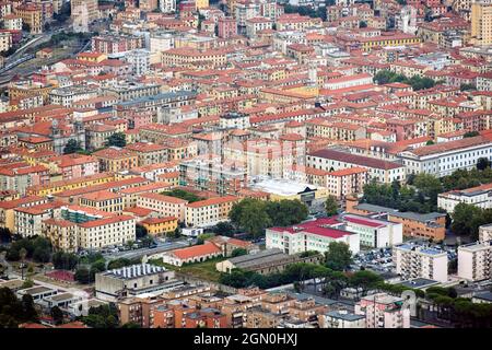 Vista con droni di molti edifici residenziali con tetti rossi e alberi lussureggianti situati sulle strade della città Foto Stock