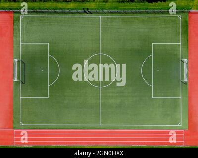 Da sopra vista aerea del campo da calcio verde vuoto con linee bianche e gol sullo stadio sportivo in estate Foto Stock