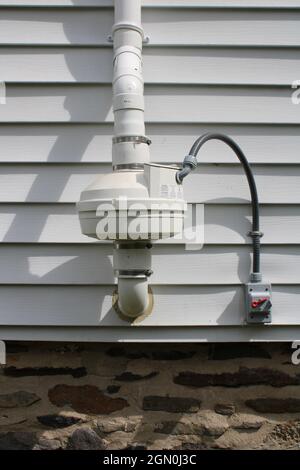 Un sistema comune di mitigazione Radon sul lato di una casa Foto Stock