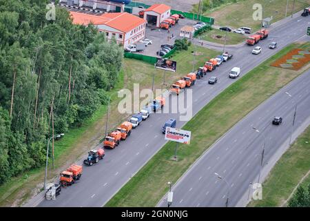 Le attrezzature stradali per il lavaggio delle strade si trovano in una colonna sulla strada con auto e camion - Mosca, Russia, 15 luglio 2021 Foto Stock