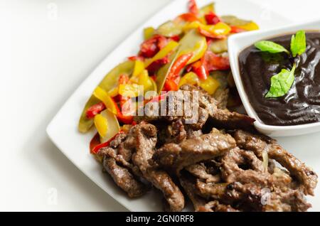 Strisce di manzo con peperoni misti e mangetout serviti con salsa di fagioli neri, pasto cinese Foto Stock