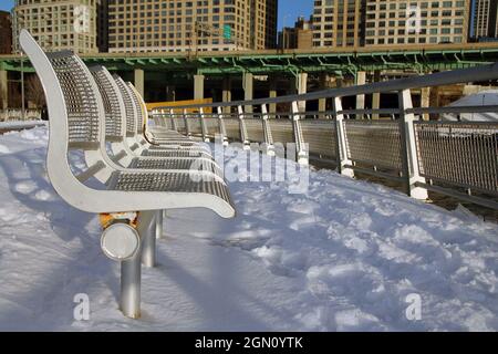 Le panchine, la neve, il fiume, l'autostrada e i grattacieli di New York City Foto Stock