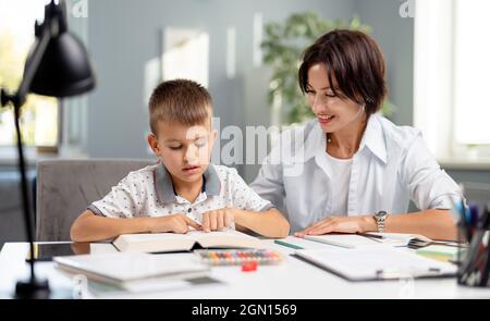 Libro di lettura ragazzo con la madre Foto Stock