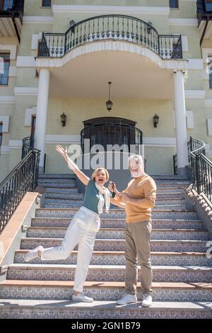 Coppia che vanta del loro nuovo acquisto sulla scala di lusso Foto Stock