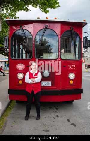 Donna conducente si trova di fronte al Red Tourist Bus, Kingston, Ontario, Canada, Nord America Foto Stock
