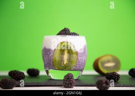 Primo piano di un budino nero di chia con mora e kiwi Foto Stock
